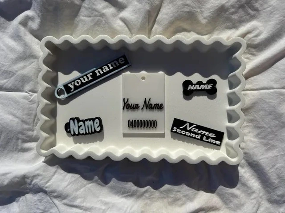 A collection of Pilly & Woof Prints name badges, keyrings, luggage tags, bag tags and pet tags